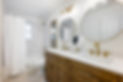 Bathroom with sinks, mirrors, and fixtures; gold accents on a white background.