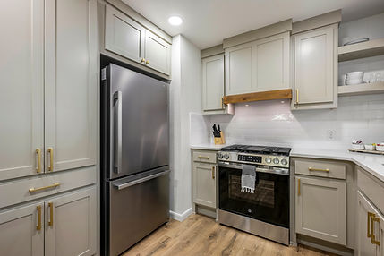 Modern kitchen with stainless steel appliances and light gray cabinets, well designed. Remodeled by Northern Pines Construction of NWA.