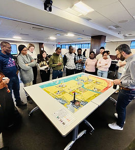 “You learn more about a person in an hour of play than a year of conversation.” – Plato If you look at other human-made systems such as healthcare, agriculture, fishing, clothes manufacturing, mining, transportation, etc. you can see they’re all in transition. In the end, these transitions will rely on sparking the most difficult change of all: human behaviour. It will require a deeper systemic understanding. It was silent in the room and the windows were fogged. Twenty-two slightly bewildered faces stared back at me. We had just played our energy transition role playing game, The Newtonian Shift , for the first time with the leadership team of the Eneco Group, an innovative Dutch energy utility company. After four hours of dynamic game play, the silence gave participants time to make sense of what happened. I hesitatingly opened the conversation: “And…how are you all doing?” “I’m surprised by how much this experience feels like real life in our organization,” one participant shared.” I had the Accounts Manager role, which allowed me to negotiate and make deals with other players. But in the second round, my clients created their own energy for a much lower price and were selling it. They even asked me if I wanted to buy energy from them! It was like the world turned upside down. I feel like this in real life too. With all these industry changes, it’s hard for me to find my place. Another player joined in: “I took the opportunity to play as ‘Boogle’ (aka Google) in the game. In this role, I could really disrupt the energy system and I took that opportunity,” he smiled from ear-to-ear. “I deliberately put people out of business that belong to the same industry as we do in real life.” “It helped me realize that if we don’t start collaborating with these disruptive organizations to change our existing business models, we won’t be around much longer.” This conversation went on for a long time, creating a mutual sense of urgency to address market and resource issues, and fueling a conversation that is still happening in their company. The game quickly prompted new questions, presented different perspectives, and sparked creativity. It created a level of conscious incompetence, highlighting gaps, so organizations could make plans and develop ideas to change patterns, behaviours, and leadership. If the game could have this impact on a company, could it also inspire and influence an entire system? In 2015, Cheryl DePaoli, Alberta Real Estate Foundation ED, connected us with The Energy Futures Lab. The EFL is dedicated to the same principles as we are: new ideas, moving beyond polarization to build empathy, and fostering collaboration. We learned that when it comes to the energy system, Albertans were asking big questions, dealing with great challenges, and needed new methods. Our initial encounter with the EFL was also at the time of the Alberta election, where the NDP won by a landslide, changing the political landscape in the province. We couldn’t ask for better timing. The Eneco Group, commissioned my company, Fresh Forces , to create this game in 2013. They wanted an experience that brought the energy transition closer to the hearts and minds of their 7,000 employees. It did this remarkably well, and became a catalyst for many other energy transition related initiatives within Eneco, co-created by Fresh Forces, including a new performance management program, creative team sessions, an innovation battle, and a leadership development program. The game provided a space to explore a new energy narrative. It seemed changes in the energy sector were only being communicated in media headlines and academic papers, with numbers, graphs, and charts. And, too often, the tone reflected the old human habit of blame and shame: it was always the fault of corporations, consumers, the government, or another particular group. We wanted the game to go beyond a circular debate and pointing fingers. It needed to increase understanding and empathy, acknowledging that successful collaboration requires trust. Gaming is no panacea, but it’s an important tool to access a deeper level of understanding. We played many times with teams and departments within the Eneco, before joining forces with the utility company to bring the game to organizations in Europe and North America, including Alberta with the EFL. Together, we adapted the game to better resemble Alberta’s energy system, including an oil company responsible for tar sand extraction and a First Nations community. It has been played with the Fellows a few times now and is ready to be played within their partner organizations. Fresh Forces and the EFL also facilitated the game during GLOBE 2016 in Vancouver, with a diverse mix of participants working in energy systems across the world. One of the founding fathers of gaming and simulation for organizational change, Richard Duke, wrote a groundbreaking book called: Gaming: the Future’s Language. Having worked intensely with gaming and simulation for over ten years now, I believe this future has arrived. If you look at other human-made systems such as healthcare, agriculture, fishing, clothes manufacturing, mining, transportation, etc. you can see they’re all in transition. In the end, these transitions will rely on sparking the most difficult change of all: human behaviour. It will require a deeper systemic understanding. Collaboration will become increasingly important as we fall back on our tendencies to blame and shame. We will have to embrace that we are all in this together. So we might as well show compassion and work with one another. And beyond the important function gaming and simulation plays in systems change, how cool, liberating, and fun is it to just PLAY with each other? ——- Join the EFL and play The Newtonian Shift on May 26th . #Culture_Shift #The_Newtonian_Shift #2016