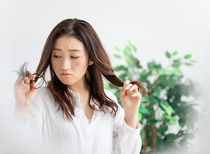髪のダメージに悩む女性