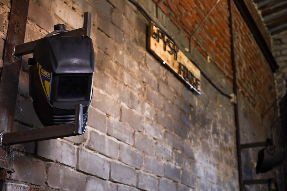 Welding mask hanging on a brick wall for Forging Ukraine