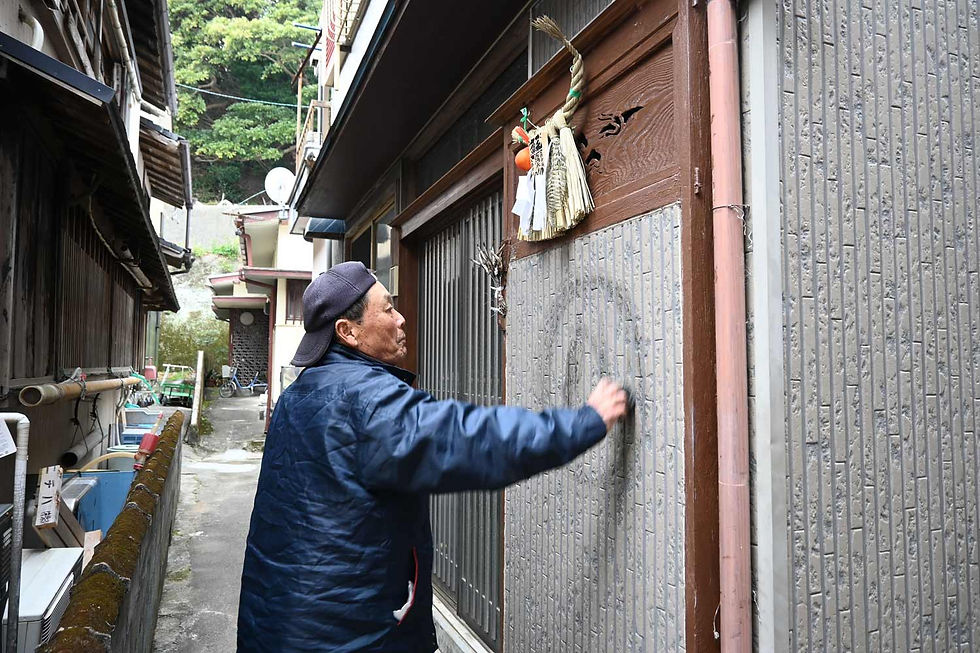 Marking the home with the deity's crest for a year of safety.