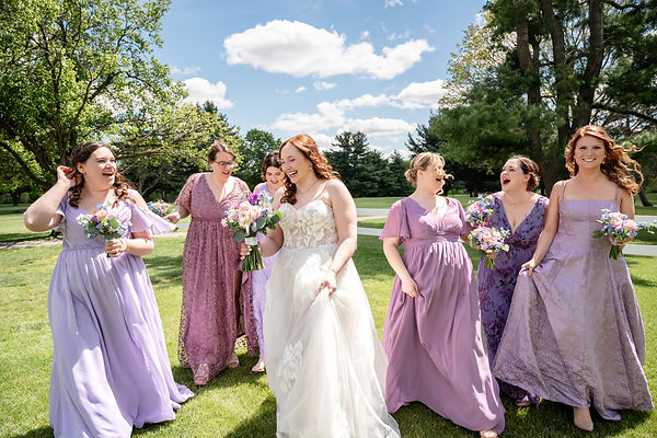 Bride laughing with her bridesmaids during an outdoor wedding at an elegant Indiana wedding venue.