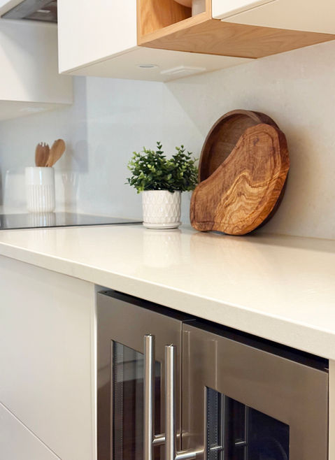 Modern white kitchen. White quartz countertop and backsplash, beverage wine fridge and induction cooktop. Designed by From a Seed Interiors, Ottawa, ON.