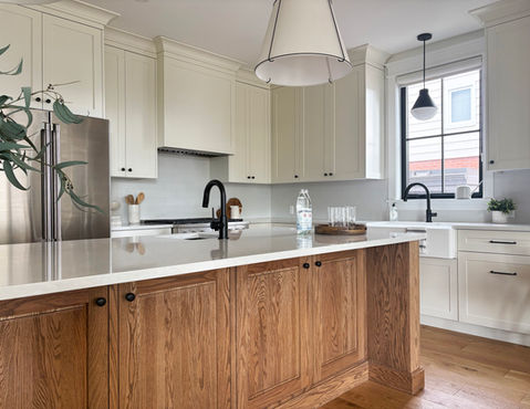 Modern farmhouse kitchen with beige painted cabinets, a warm oak wood island, and light quartz countertops. Large island pendant lights. Designed by From a Seed Interiors, Ottawa, ON.