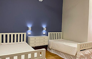 Quarto de hóspedes com cama de casal e solteiro que acomoda 3 idosos
