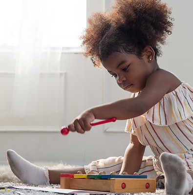 Cute little mixed race toddler girl playing with wooden toy xylophone..jpg