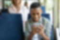 happy-black-guy-using-cell-phone-in-bus-2022-12-16-08-23-49-utc.jpeg