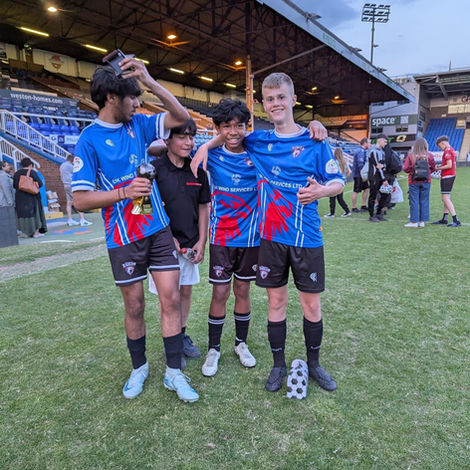 Young men of a soccer team smiling at a stadium