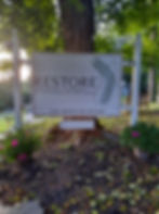Restore Physical Therapy and Integrative Wellness Sign with flowers in front of tree