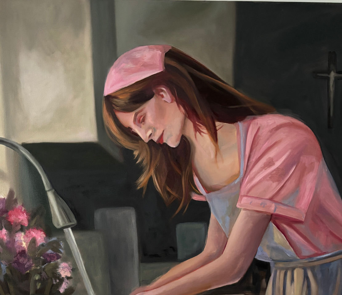 Woman in pink dress and gray apron washing her hands.