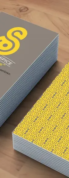 Two stacks of business cards, one showing the from of the card, and the other showing the back. Both feature the Sinhala Spice branding.