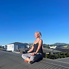 Elena amani in meditation pose on the roof of her yoga studio in Canberra