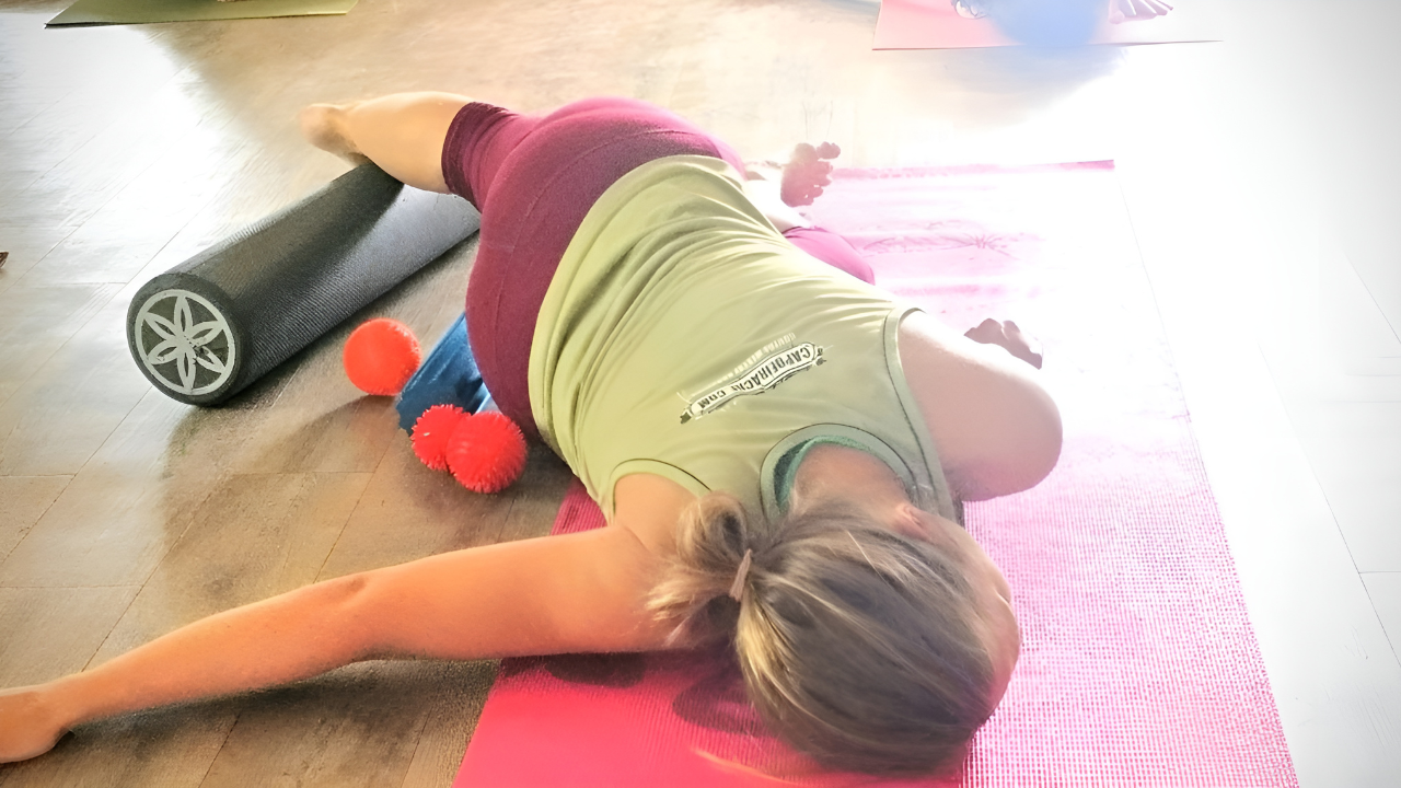 Woman is using massage balls to release pain in her shoulder