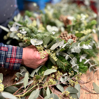 Evergreen foliage on wreath with arm and hand