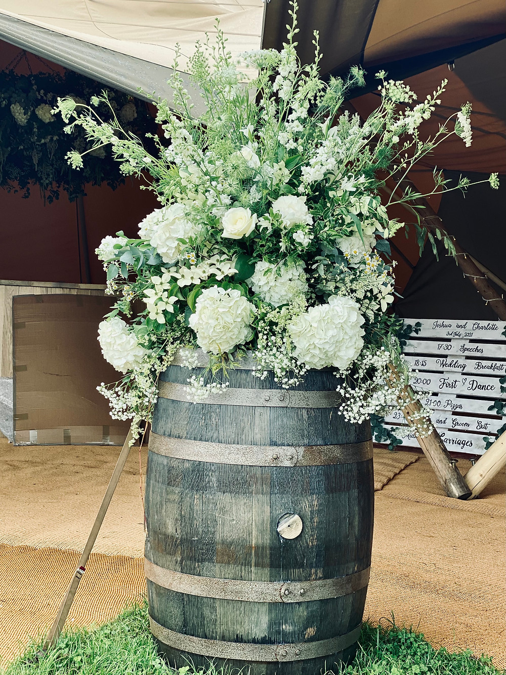 wine barrel with large white and green floral display
