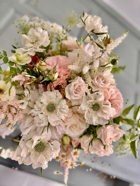 Gathered garden style bridal bouquet with soft peachy pink and cream seasonal flowers.