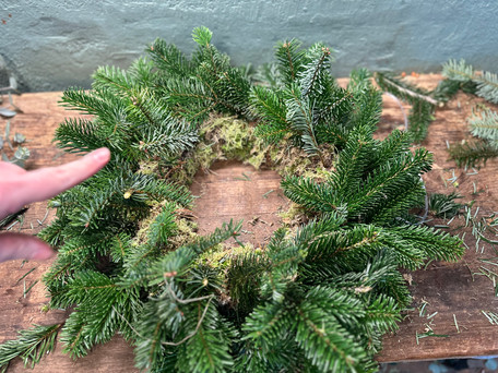 evergreen wreath and pointing finger