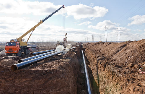 Construction work on the pipe laying of the pipeline into the trench using a crane.jpg