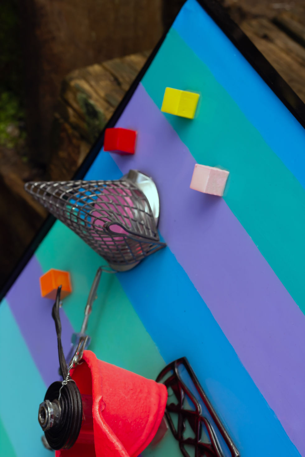 Thumbnail: ngled detail of the top corner with wire basket element, coloured cubes and metal arm components.