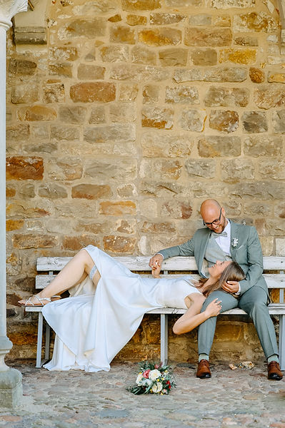 Ein Brautpaar sitzt auf einer Holzbank im Schloss Leitzkau.