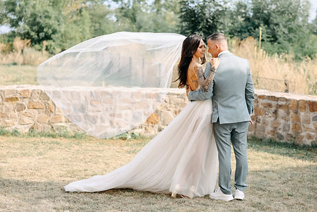 Ein Hochzeitspaar hält sich im Arm und der Schleier weht im Wind. Diese Aufnahme ist vom Hochzeitsfotografen Magdeburg Christian Gander.