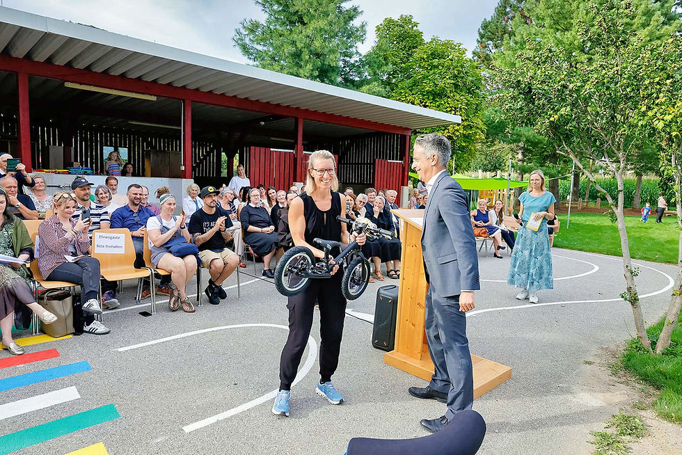 Einstandsgeschenk: Stadtrat Kurt Hohensinner überreicht der Einrichtungsleiterin Elisabeth Reicher ein Laufrad.