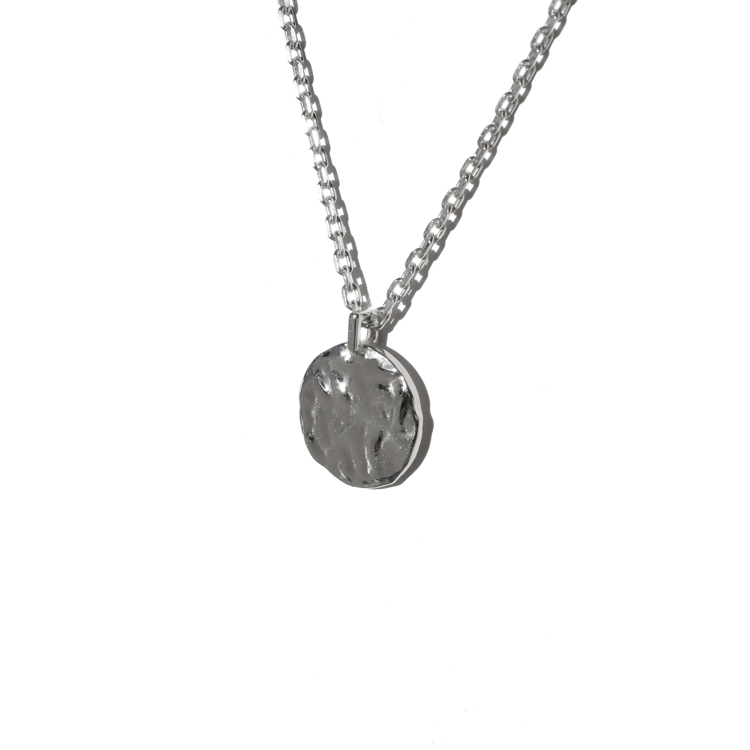Handmade sterling silver round pendant necklace with organic molten texture, worn on chain and photographed in natural light.