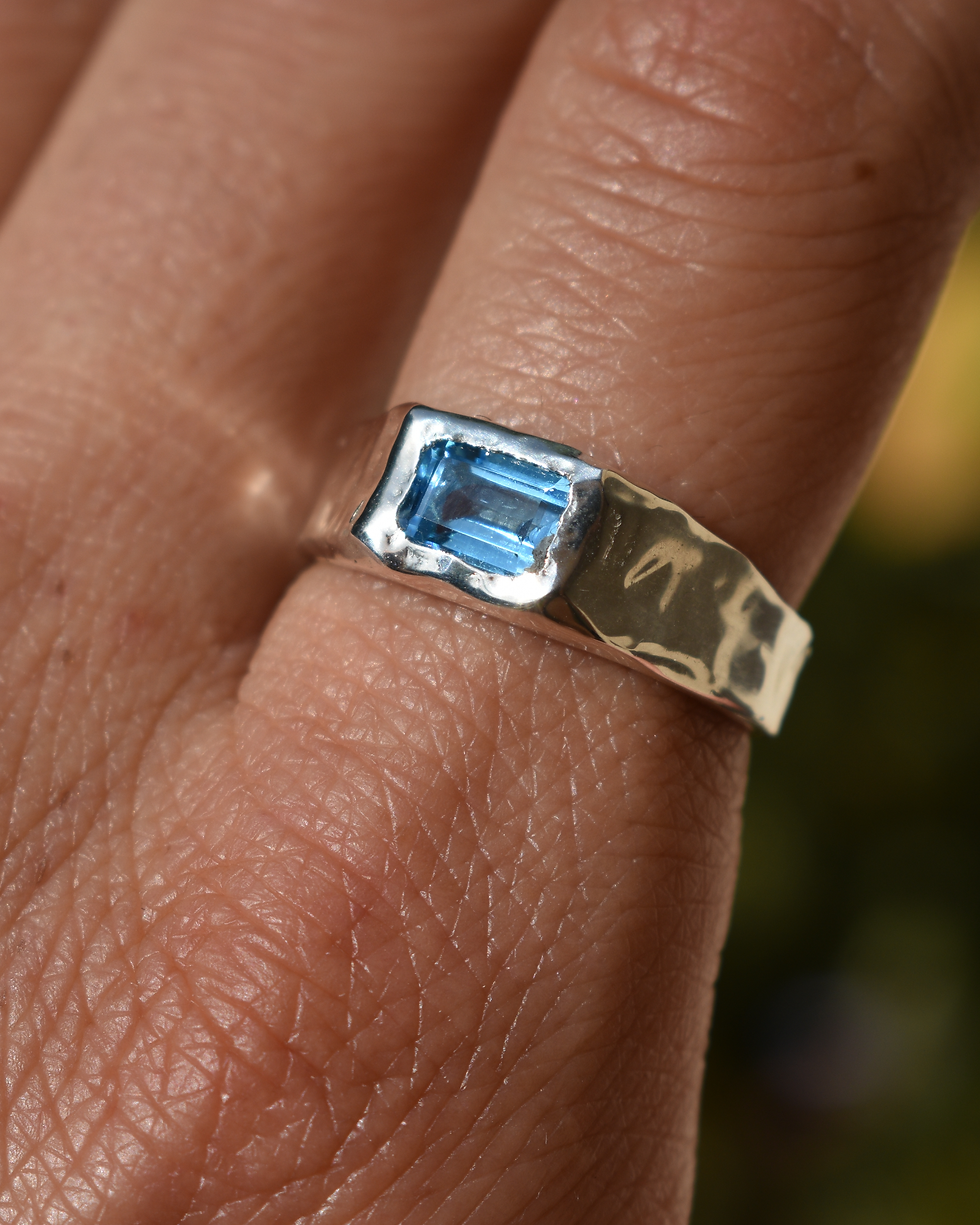 Thumbnail: Handmade sterling silver ring with rectangular blue topaz, polished organic gemstone band with sculptural silver design