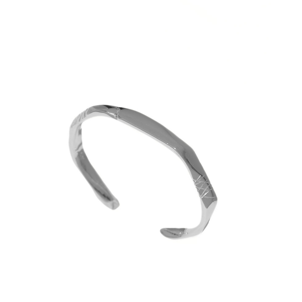 Thumbnail: Sterling silver open cuff bracelet with raw finish and carved detail lines, worn on wrist.