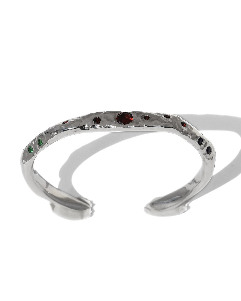 Thumbnail: Handmade sterling silver cuff bracelet with raw texture and garnet stones, worn on wrist, organic artisan jewelry