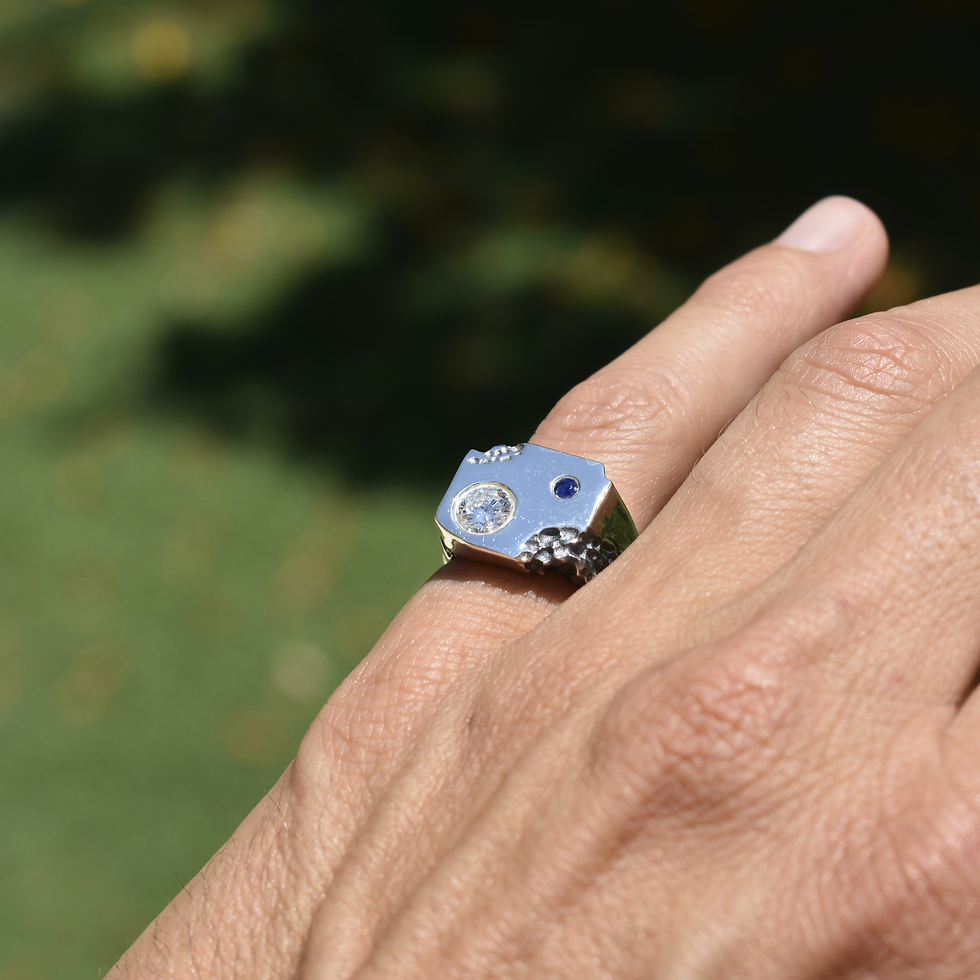 Thumbnail: Sterling silver ring with lava-texture detail, lab diamond and blue sapphire on a wide angular band.