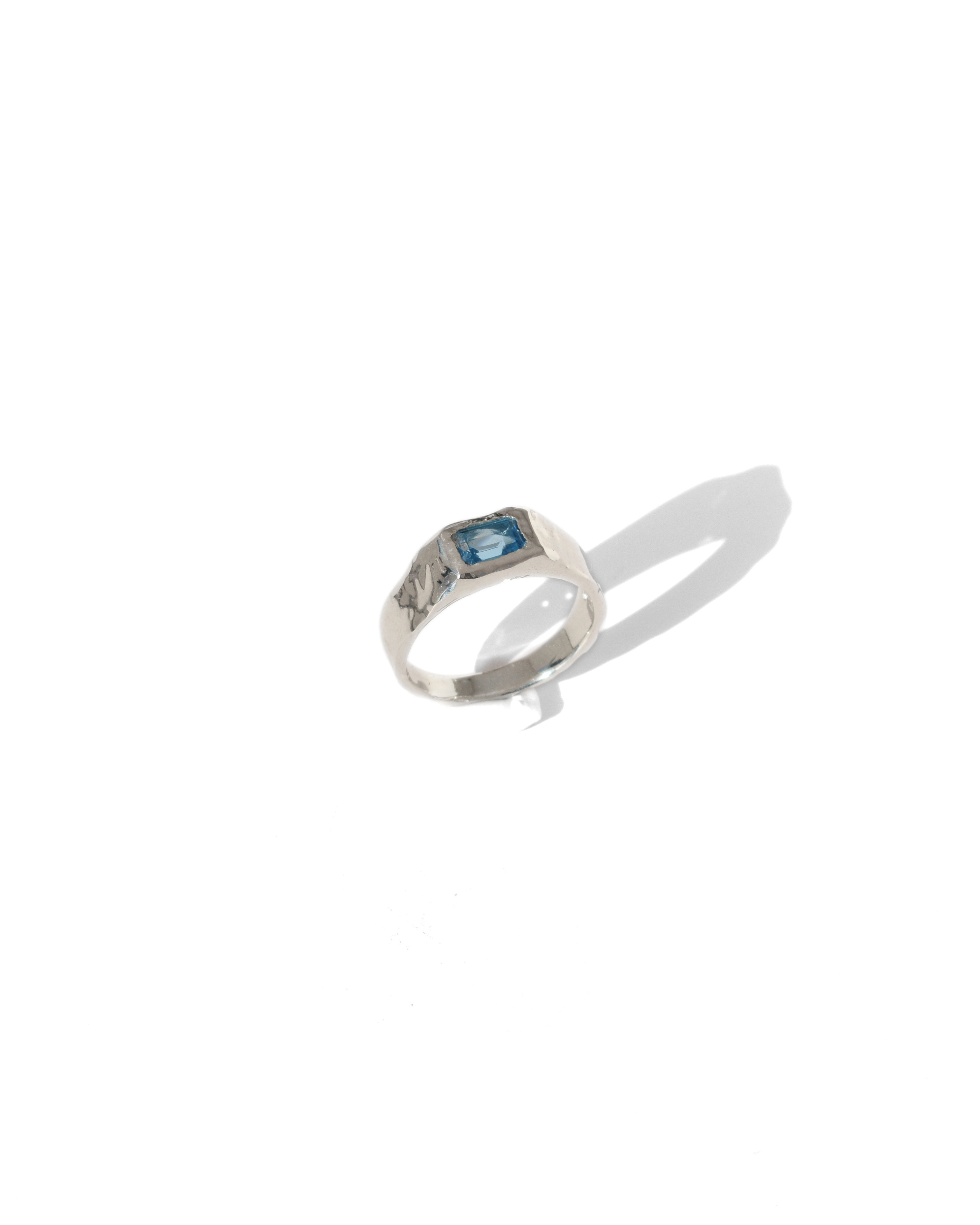 Handmade sterling silver ring with rectangular blue topaz, polished organic gemstone band with sculptural silver design