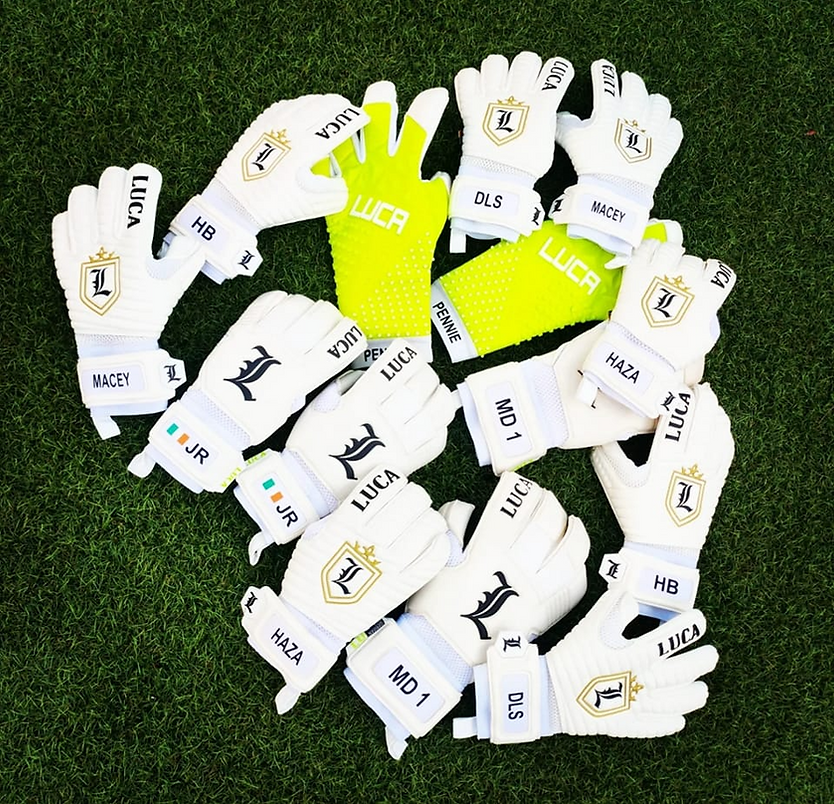 Luca Goalkeeping gloves in white laid on grass