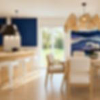 Rénovation complète d'un séjour avec cuisine ouverte et décoration personnalisée couleur vive et bleu roi par une architecte d'intérieur en Savoie.