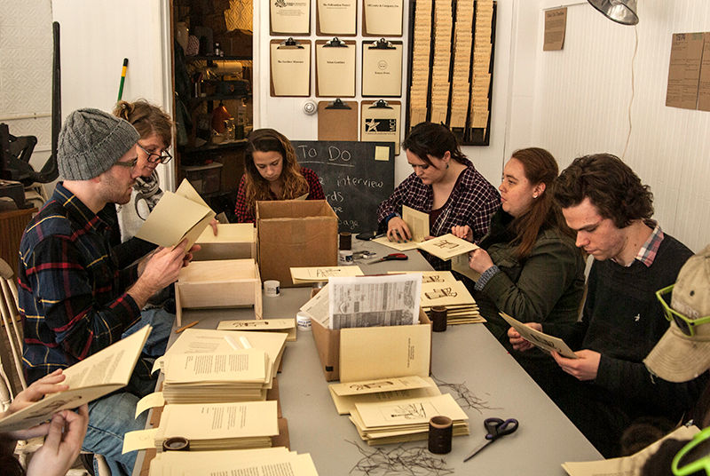 A class of book arts students from the New Hampshire Institute of Art helps bind the books; photo credits to Paul Gingras