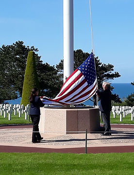 Lowering the flag at Colleville cemetery