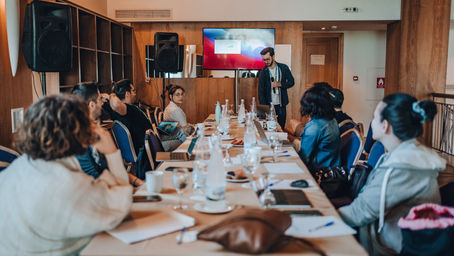 Team gathered in a conference room for a presentation during an offsite meeting organized by Get Lost in Greece
