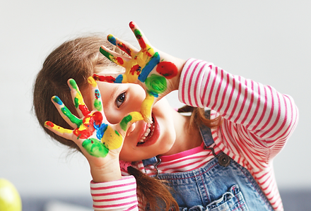 Preschool child showing painted hands in Butterfly Learning Centre’s Daycare Program for ages 3–5 years