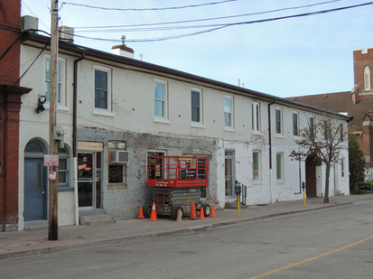 Before painting: faded and stained red brick wall.