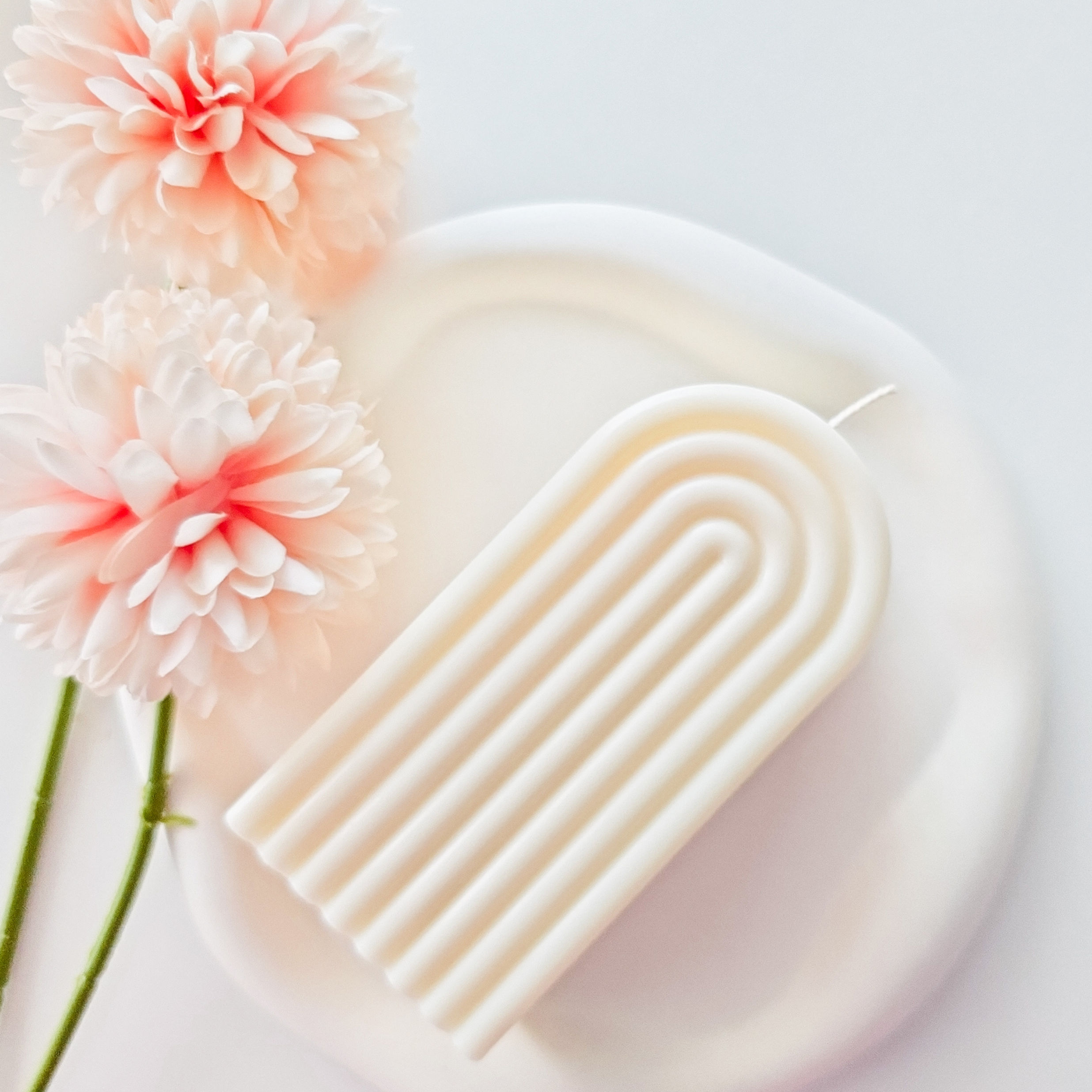 A handmade Rainbow Candle with a minimalist arch design, crafted from natural rapeseed wax, displayed on a light decor settin