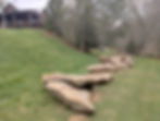 Natural rock border on a green slope