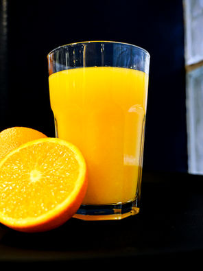 Glass of fresh orange juice with a sliced orange