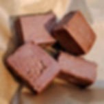 Four cubes of milk chocolate fudge on kraft paper