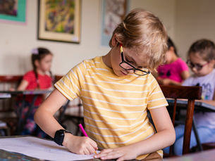 Kids writing in a classroom