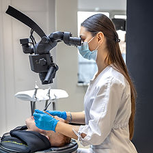 young-female-dentist-treating-patients-teeth-with-dental-microscope-dentistry-concept.jpg