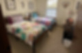 Bedroom with colorful quilt bedding inside Meme's Retreat Center Moore Oklahoma
