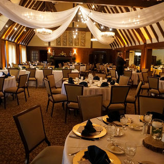 Indoor Country Club Wedding Reception with Centered Ceiling Draping, bulb rope strands and gold charger plates 
