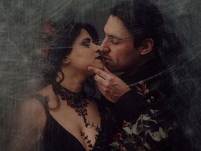 Un primo piano suggestivo di una coppia gotica che si bacia, vestita con pizzi neri e abiti scuri, su uno sfondo grigio sfocato. Fotografia di Drimage Creative studio di Simona Turano Fotografa e Wedding Planner & Designer