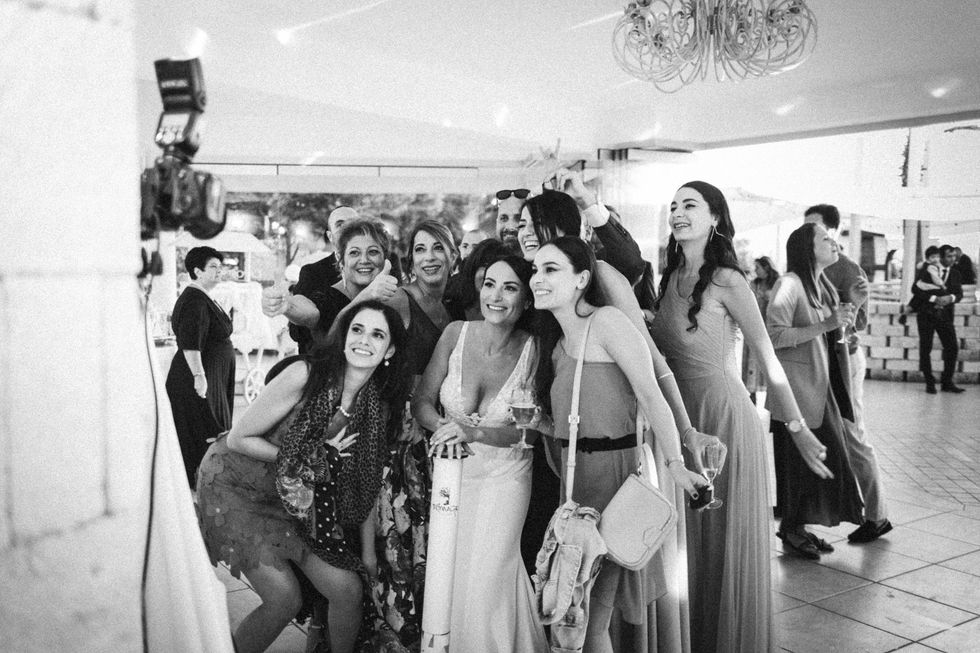 Gruppo di donne sorridenti in abiti eleganti scattano un selfie. Matrimonio verde-mare.